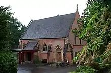 chapel-style red brick building with steep pitched slate roof