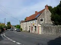 Stone shop building with cars parked outside