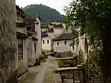 Small street lined by white houses with tile roofs.