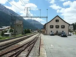 Two-story building with gabled roof next to platforms and tracks