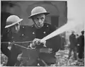 London firemen wearing Brodie-like steel helmets during World War II.