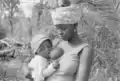 Standing mother breastfeeding her baby, Canjambari, Guinea-Bissau, 1973