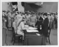 Lieutenant General Richard K. Sutherland, aboard USS Missouri, corrects a signatory error in the Japanese Instrument of Surrender. US Colonel Sidney Mashbir and Japanese Foreign Minister Katsuo Okazaki look on.