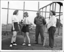 Black and white photo of an umpire with a pitcher, catcher, and batter